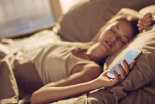 woman sleeping holding her phone