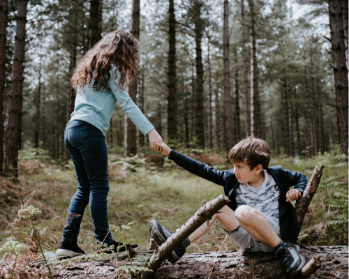 Girl showing kindness by helping boy up