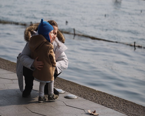 mother talking to daugher by water