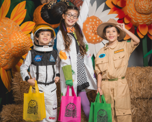 A little boy in an astronaut costume, a girl in a scientist costume, and another boy in a zoo keeper costume at Pumpkin Palooza.