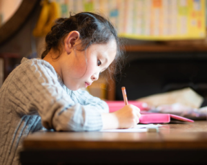 Little girl writing a letter